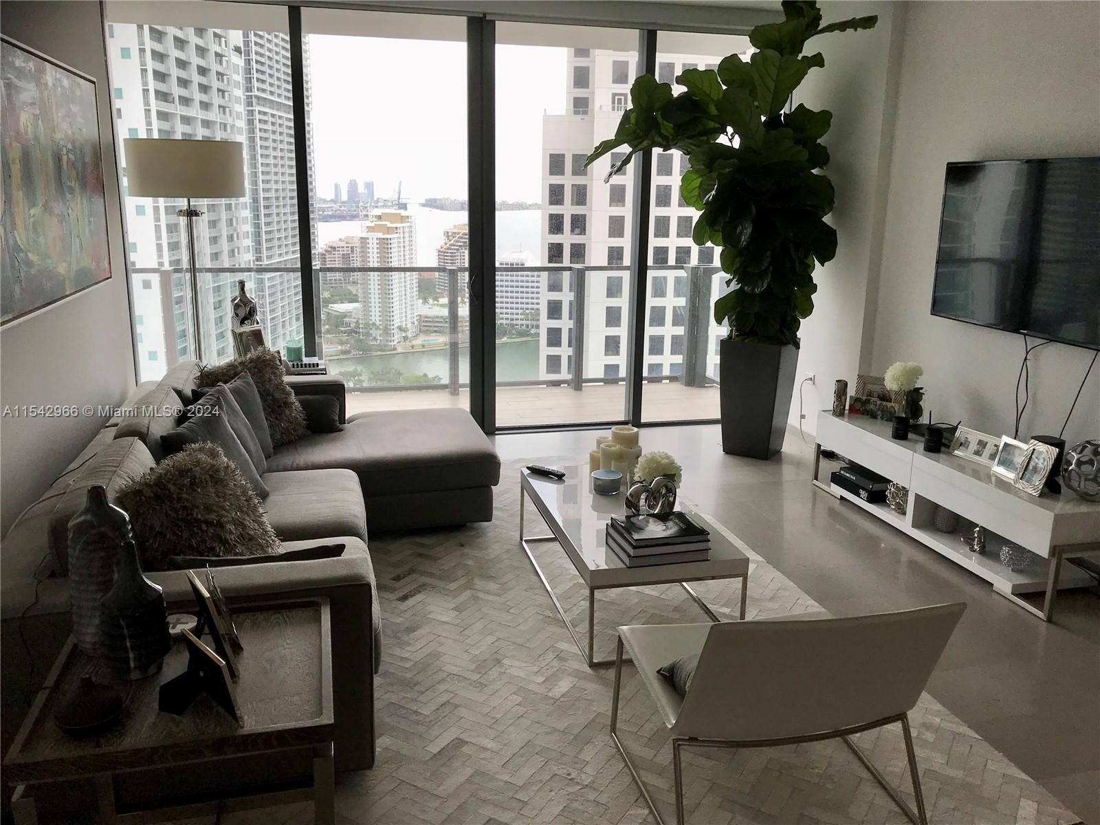 68 Southeast 6th Street, Unit 2707 Miami, FL 33131 - Photo 18 of 53 a living room with furniture rug and lamp