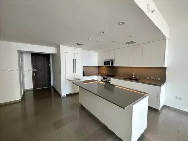 a kitchen with stainless steel appliances granite countertop a sink a stove and a refrigerator