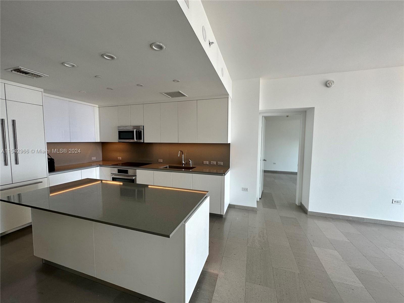 68 Southeast 6th Street, Unit 2707 Miami, FL 33131 - Photo 6 of 53 a kitchen with stainless steel appliances granite countertop a sink a stove and a refrigerator