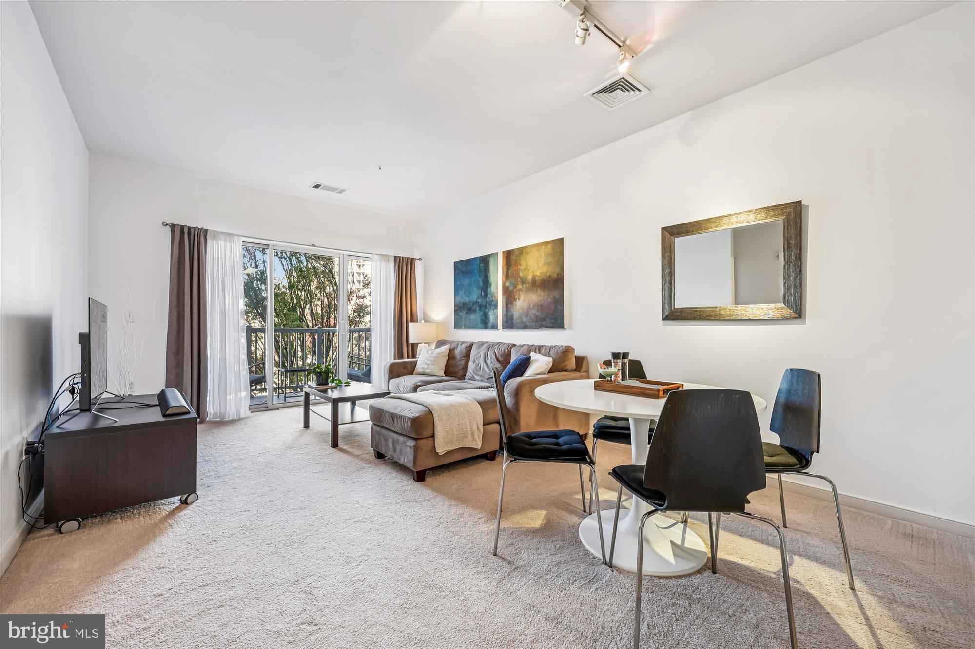 8045 Newell Street, Unit 215 Silver Spring, MD 20910 - Photo 13 of 31 a living room with furniture and a flat screen tv