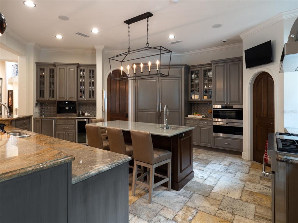 10803 Southwest 27 Avenue Gainesville, FL 32608 - Photo 25 of 78 a kitchen with granite countertop a stove a sink a dining table and chairs