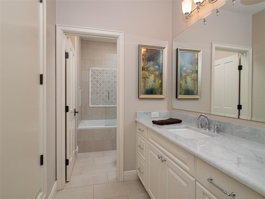 10803 Southwest 27 Avenue Gainesville, FL 32608 - Photo 38 of 78 a bathroom with a granite countertop sink mirror and a bathtub
