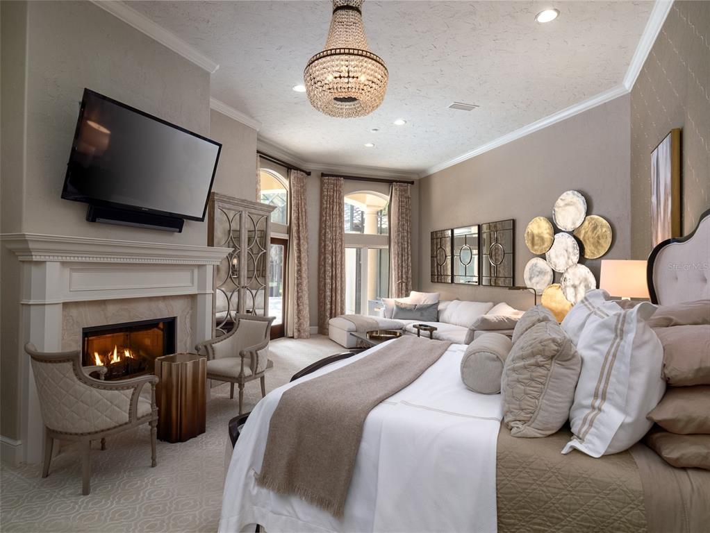 10803 Southwest 27 Avenue Gainesville, FL 32608 - Photo 44 of 78 a bedroom with bed a flat tv and a fireplace