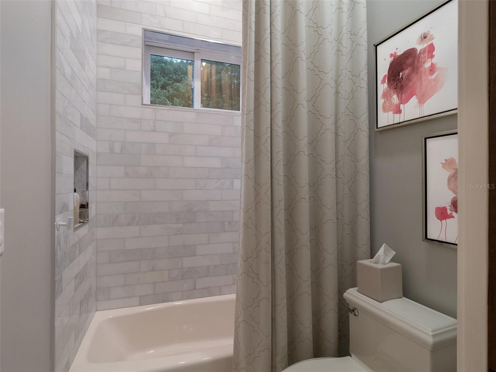 10803 Southwest 27 Avenue Gainesville, FL 32608 - Photo 45 of 78 a bathroom with a toilet and a shower curtain