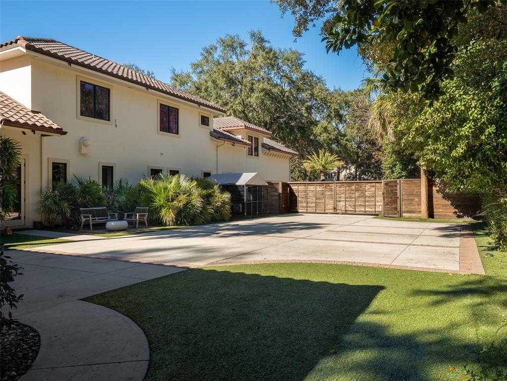 10803 Southwest 27 Avenue Gainesville, FL 32608 - Photo 69 of 78 a view of a white house with a big yard and potted plants and large trees