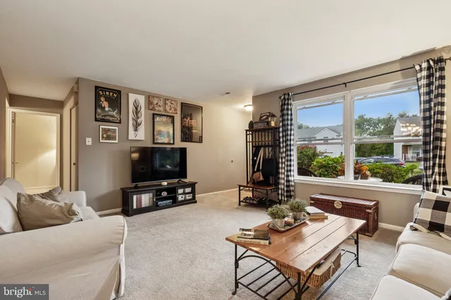 a living room with furniture a flat screen tv and a large window