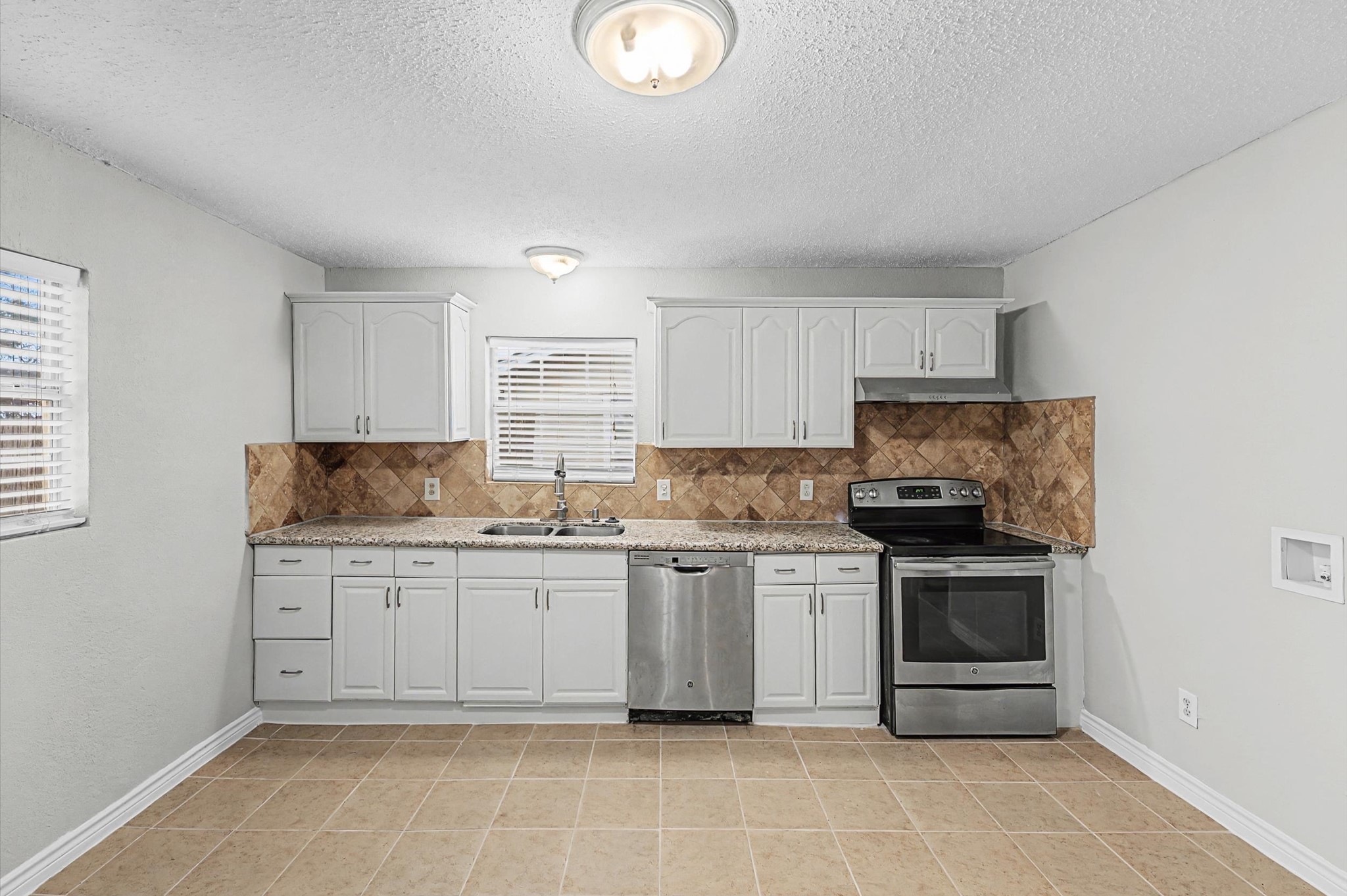 1108 Georgina Street Rosenberg, TX 77471 - Photo 5 of 15 a kitchen with stainless steel appliances granite countertop a stove sink and cabinets