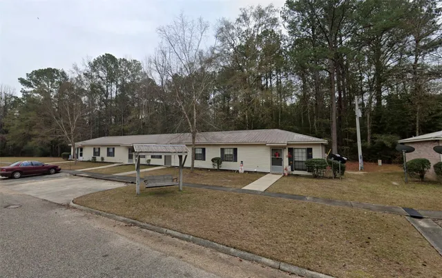 a view of a house with backyard and sitting area