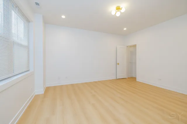 a view of empty room with wooden floor