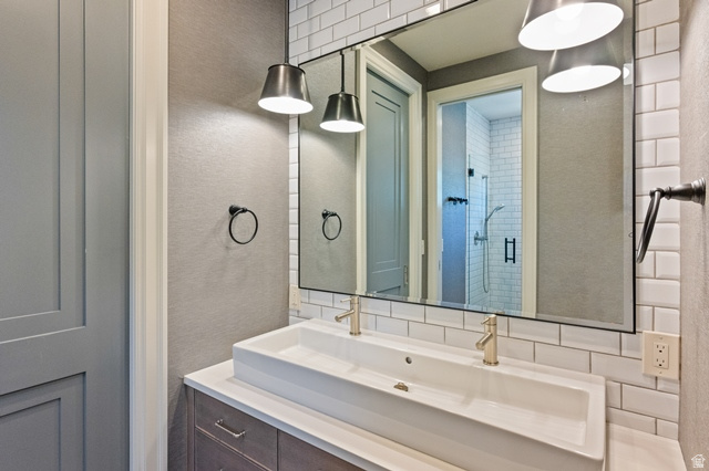 3 Carriagewood Cove, Unit 1088 Sandy, UT 84092 - Photo 40 of 79 Bathroom vanity featuring a dual vessel sink, gold-finish faucets, and a full-width mirror