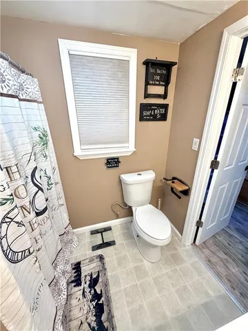 a white toilet sitting next to a shower curtain