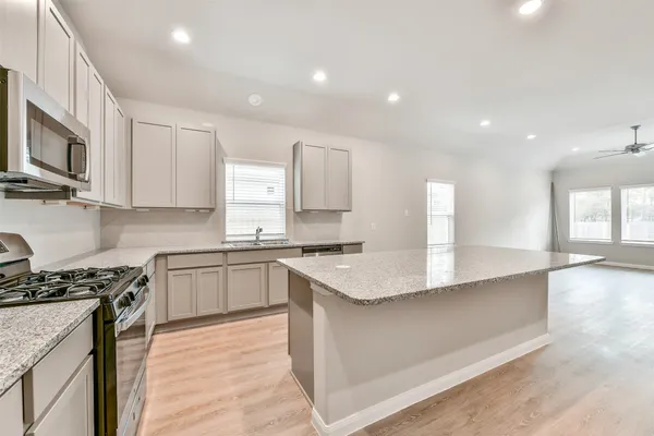a kitchen with stainless steel appliances granite countertop a sink stove and refrigerator
