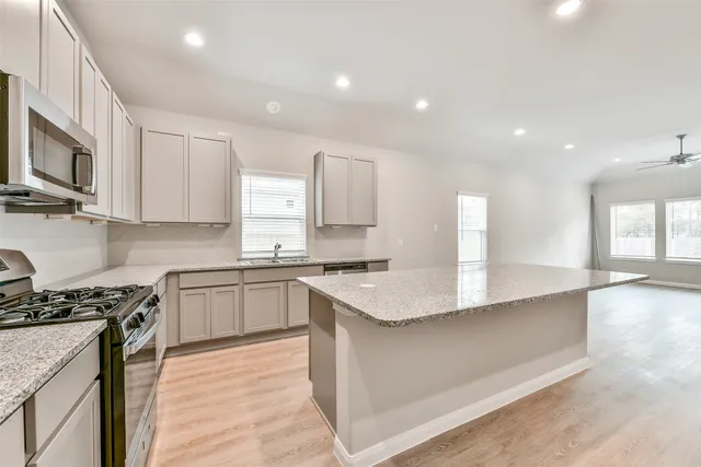 a kitchen with stainless steel appliances granite countertop a sink stove and refrigerator