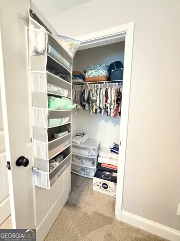 a view of walk in closet with clothes and shoes