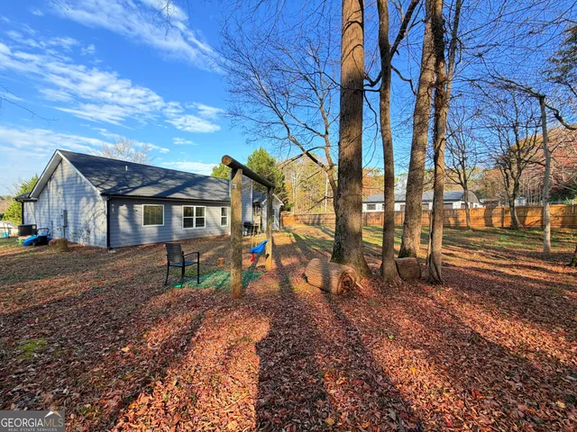 a view of a house with backyard and trees