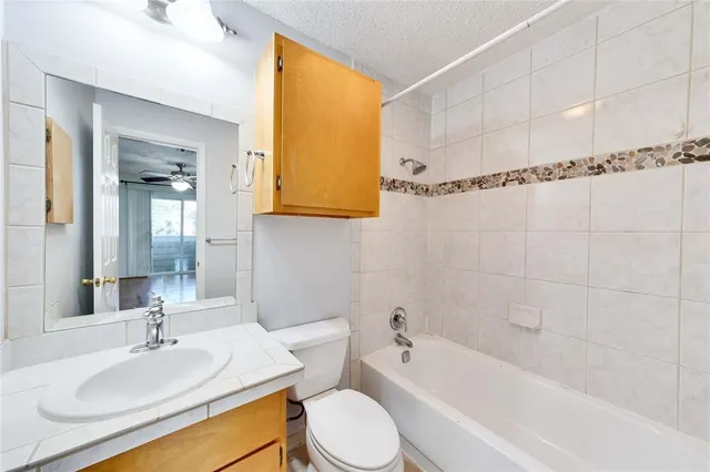 a bathroom with a granite countertop sink mirror toilet and bathtub