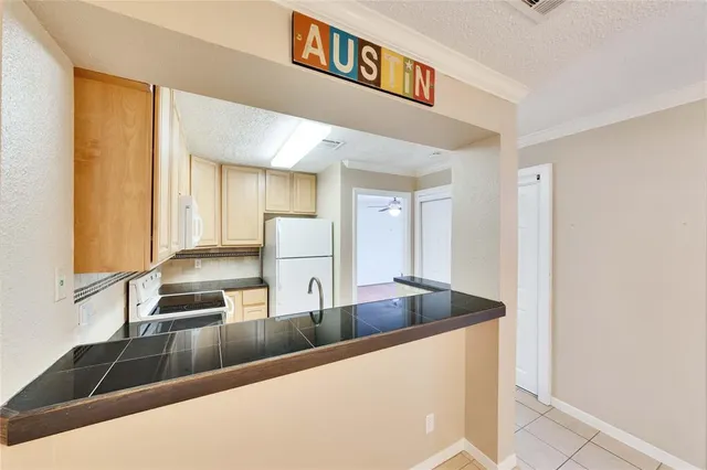 a view of a kitchen counter top space with stainless steel appliances granite countertop a sink and a refrigerator