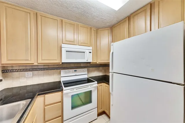 a kitchen with a refrigerator and a sink