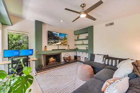 a living room with furniture a flat screen tv and a fireplace