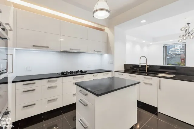 a kitchen with granite countertop a sink a stove and cabinets