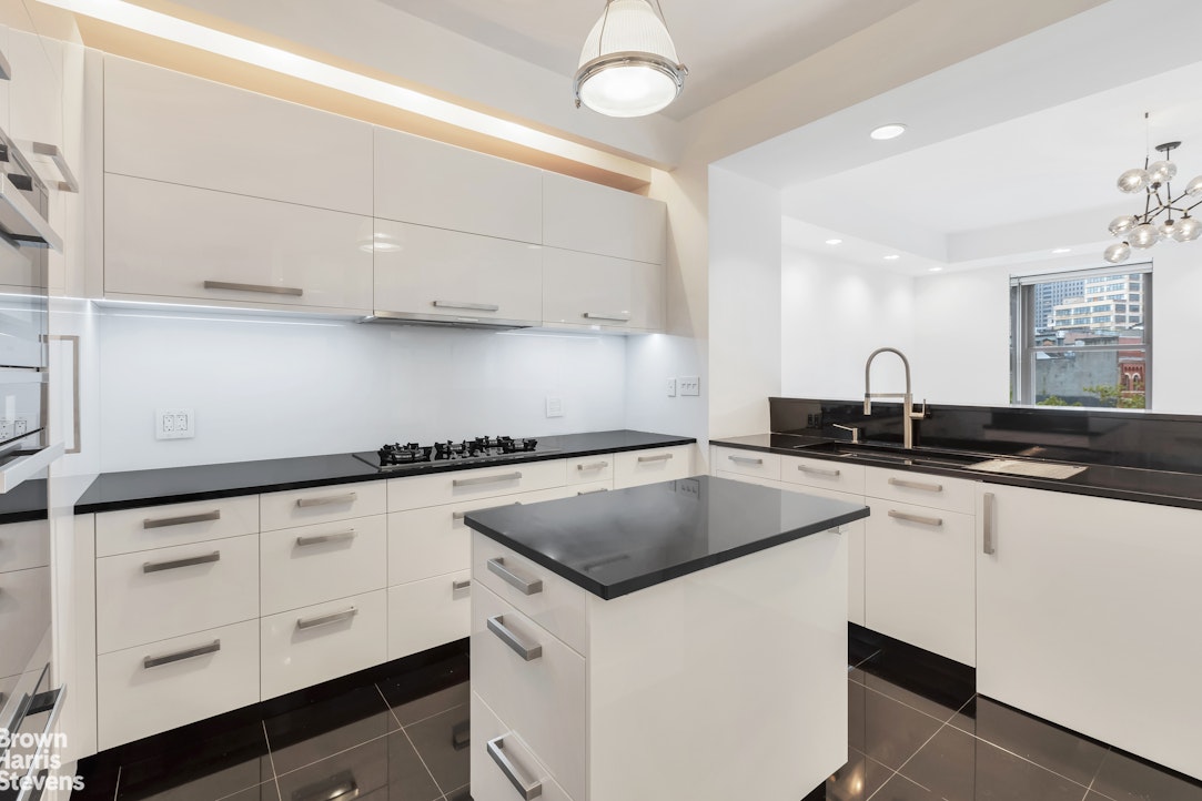 260 West Broadway, Unit 6D Manhattan, NY 10013 - Photo 3 of 15 a kitchen with granite countertop a sink a stove and cabinets
