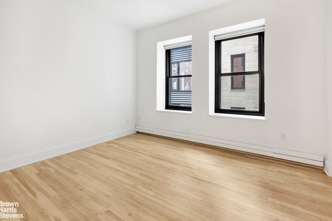 260 West Broadway, Unit 6D Manhattan, NY 10013 - Photo 7 of 15 an empty room with wooden floor and windows