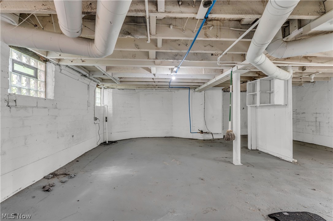 3154 Kensington Road Cleveland, OH 44118 - Photo 22 of 26 Expansive unfinished basement featuring concrete flooring, exposed ceiling joists, and block glass windows