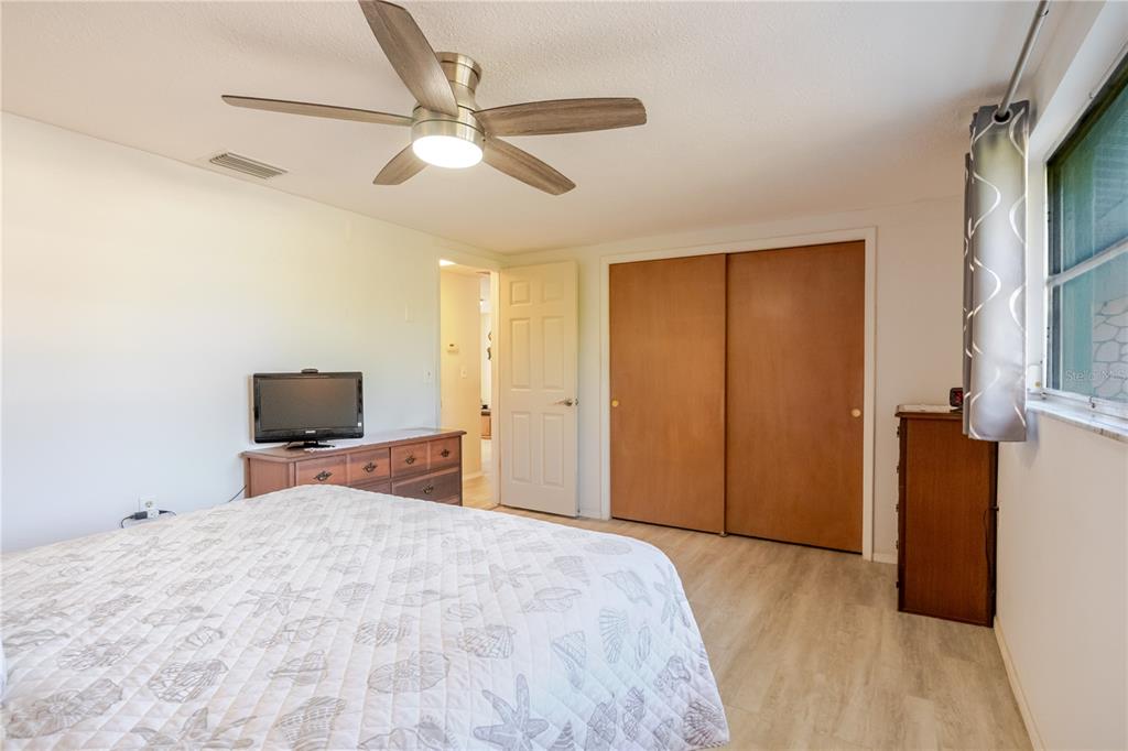 5644 Riddle Road Holiday, FL 34690 - Photo 24 of 58 a bedroom with a large bed and a chandelier