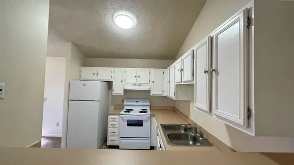 an empty room with closet and a chandelier fan