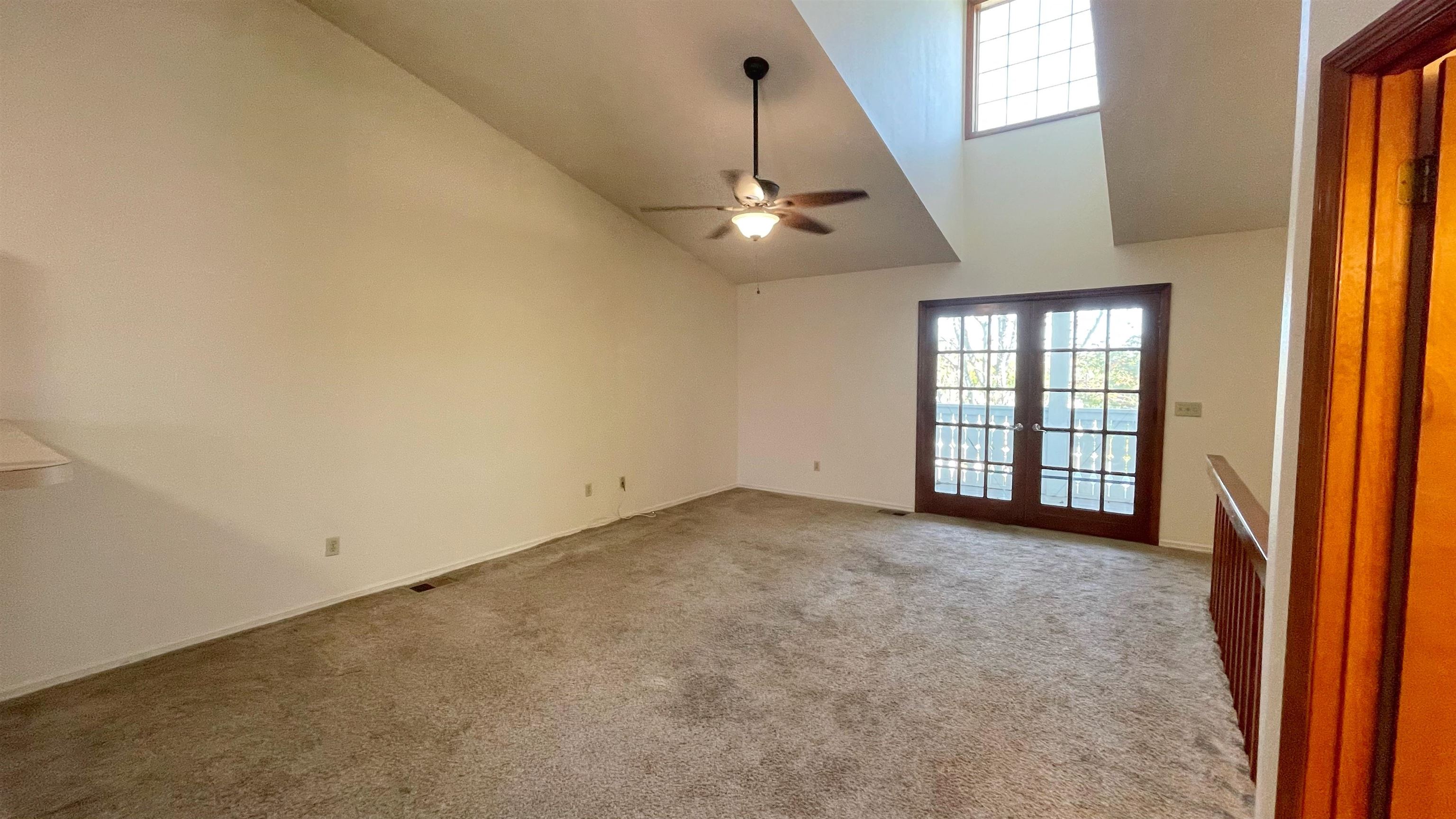 105 Arricola Avenue, Unit E St. Augustine, FL 32080 - Photo 13 of 27 an empty room with chandelier fan and windows