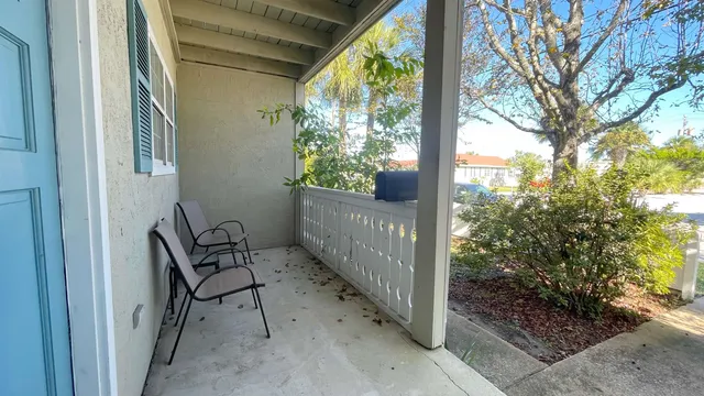 a view of a porch with furniture and floor to ceiling window