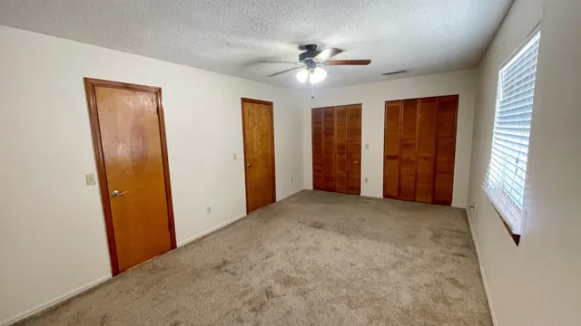 an empty room with windows and closet