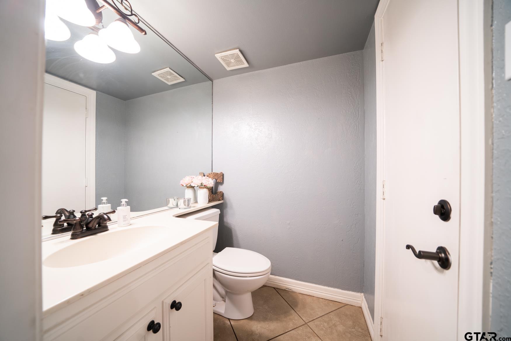 2 Joseph Circle Longview, TX 75601 - Photo 24 of 35 a bathroom with a granite countertop sink mirror vanity and toilet