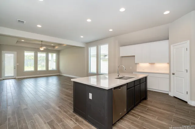 a kitchen with kitchen island sink and cabinets