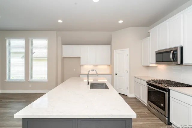 a kitchen with a stove a sink and a refrigerator