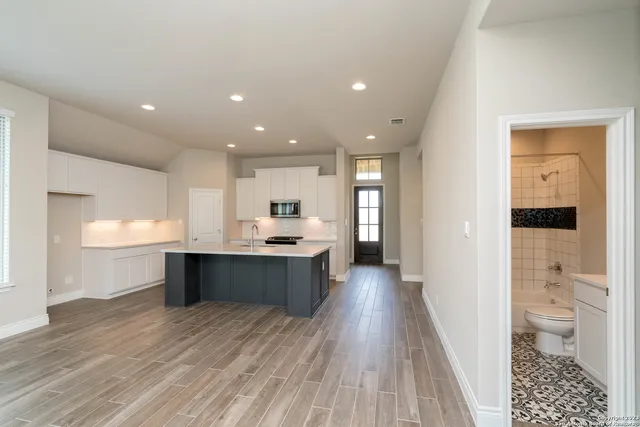 an empty room with a ceiling fan and window