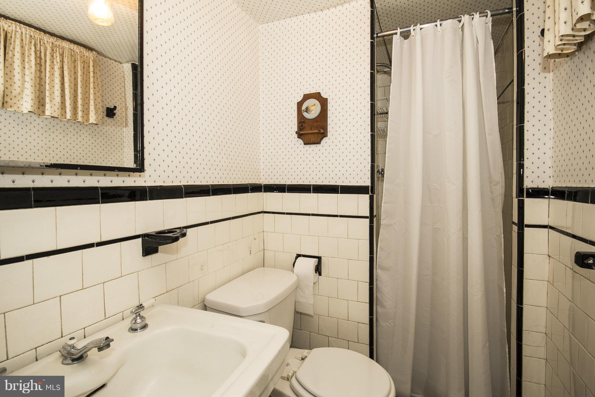 6911 Kenleigh Road Baltimore, MD 21212 - Photo 14 of 26 a bathroom with a sink a toilet and shower