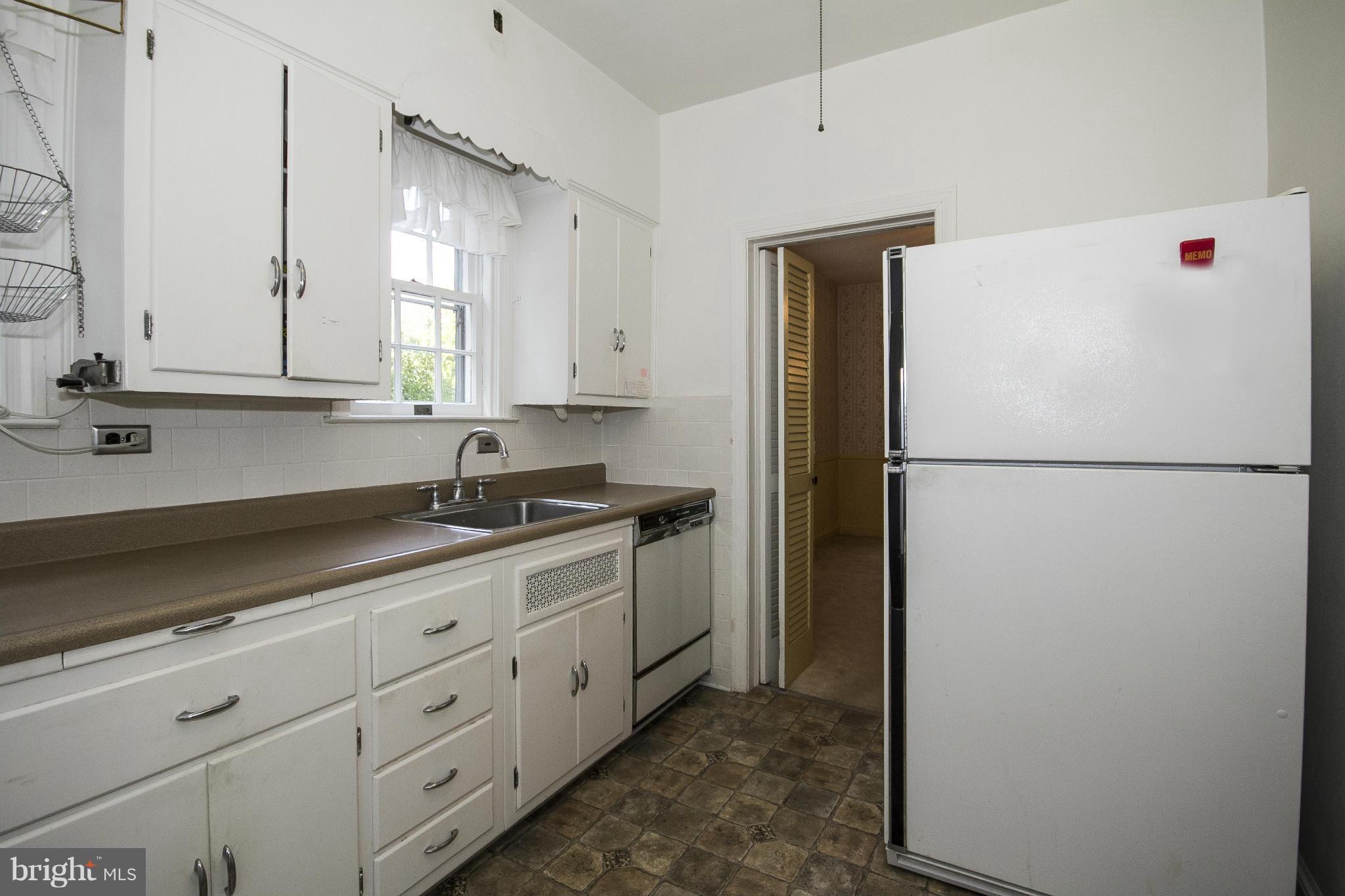 6911 Kenleigh Road Baltimore, MD 21212 - Photo 8 of 26 a kitchen with granite countertop cabinets and refrigerator