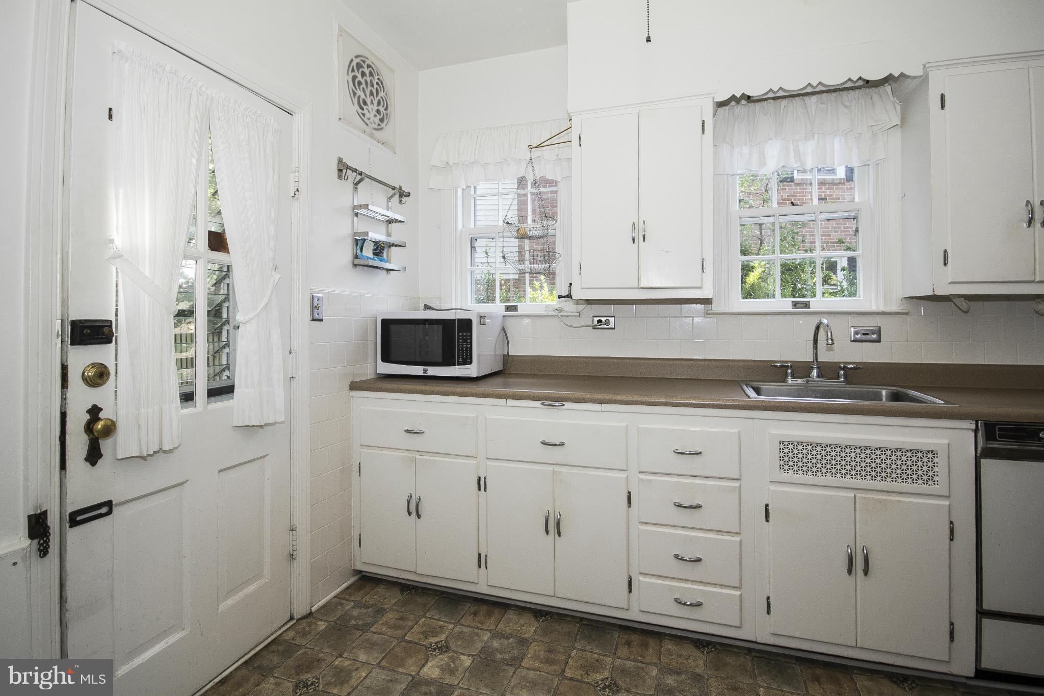6911 Kenleigh Road Baltimore, MD 21212 - Photo 9 of 26 a kitchen with stainless steel appliances white cabinets and a sink