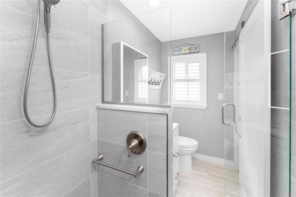 1977 Beach Road, Unit 3 Englewood, FL 34223 - Photo 36 of 56 a bathroom with a granite countertop toilet a sink and mirror