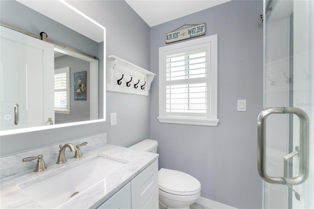 1977 Beach Road, Unit 3 Englewood, FL 34223 - Photo 37 of 56 a bathroom with a toilet sink and mirror