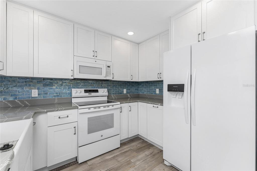 1977 Beach Road, Unit 3 Englewood, FL 34223 - Photo 8 of 56 a kitchen with white cabinets and white appliances