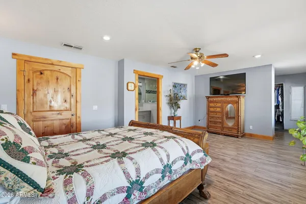 a bedroom with a bed and wooden floor
