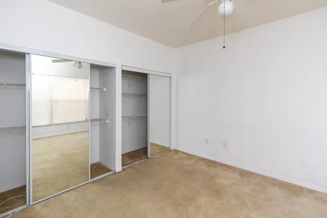 an empty room with closet and a window