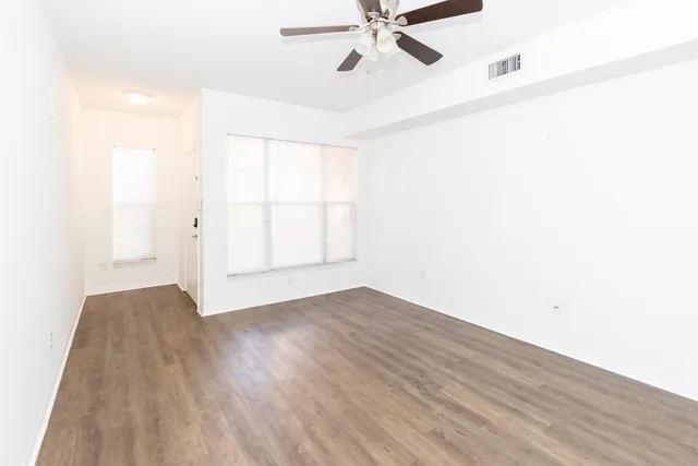 a view of a room with wooden floor and white walls