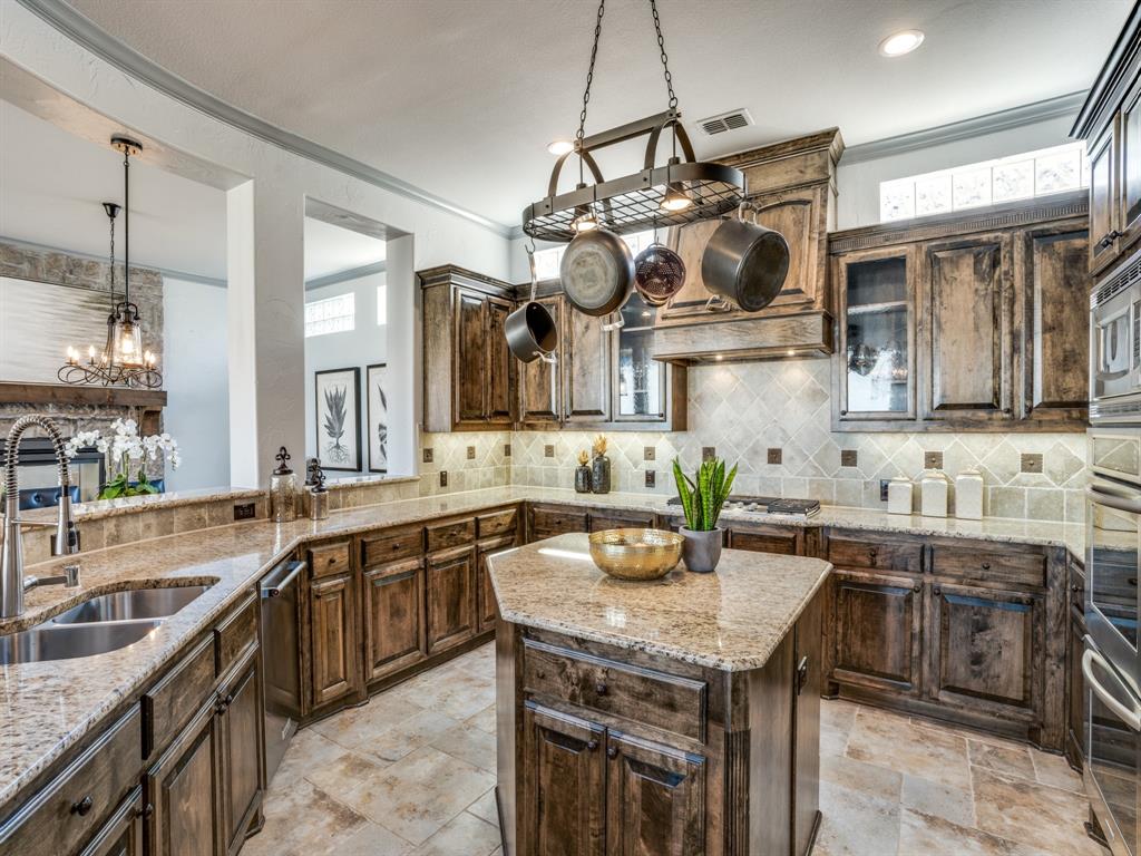 a kitchen with granite countertop a sink a counter space appliances and cabinets