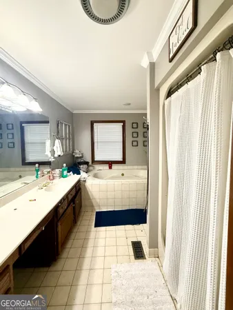 a bathroom with a tub a sink and a large mirror