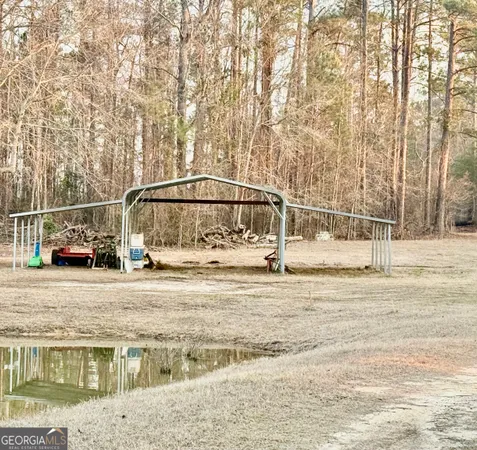 a view of dirt field with trees in the background