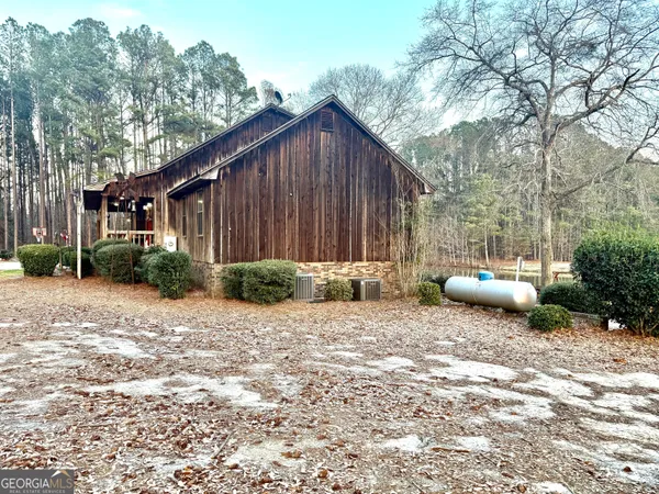 a backyard of a house with potted plants and large tree