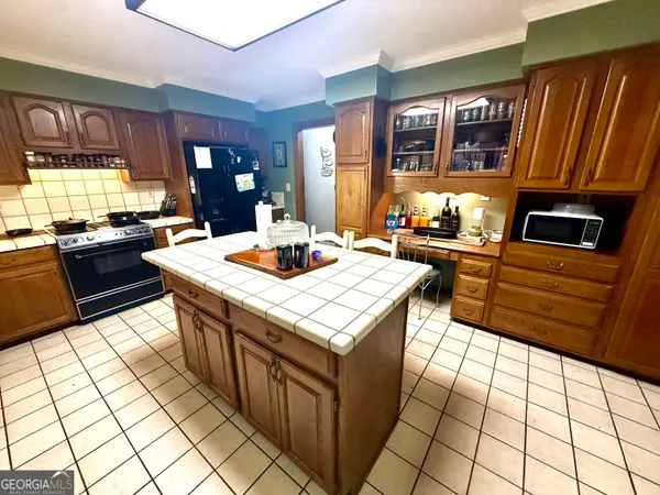 a kitchen with stainless steel appliances kitchen island granite countertop a refrigerator a stove top oven and a dining table view